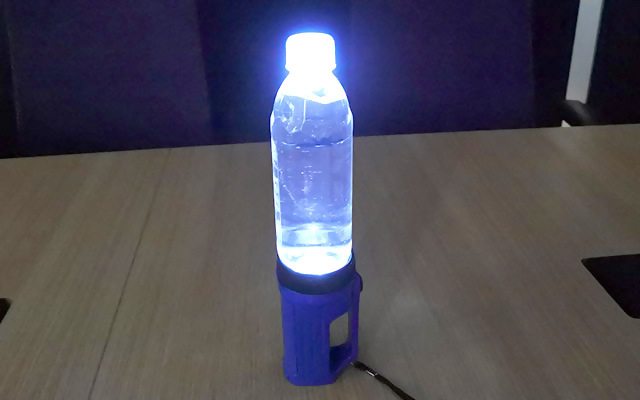 懐中電灯の上に水が入ったペットボトルをのせ、簡易ランタンとして使っている様子。