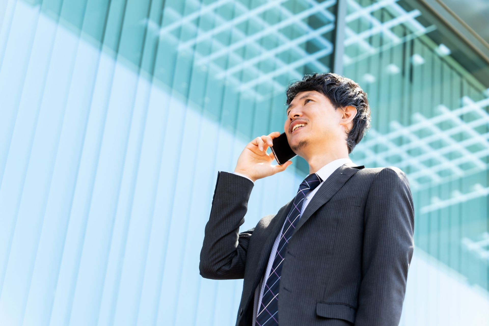 男性がスマートフォンで電話をしている様子。