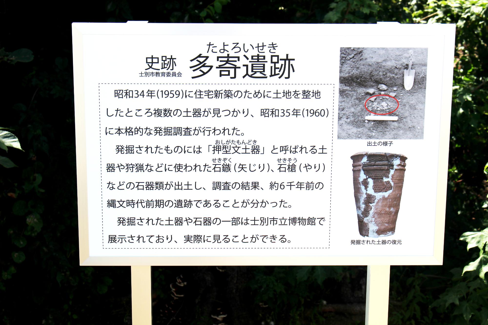 多寄遺跡の看板。昭和35年から本格的に発掘作業を行った。矢じり、やりが発見された。約6千年前の遺跡だと分かった