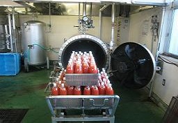 台の上に入れられ積み重ねて置かれた赤い液体の入ったボトルの写真