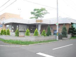 道路に面した場所で塀に囲まれ、敷地内には植栽が施された瑞祥幼稚園の建物の外観写真