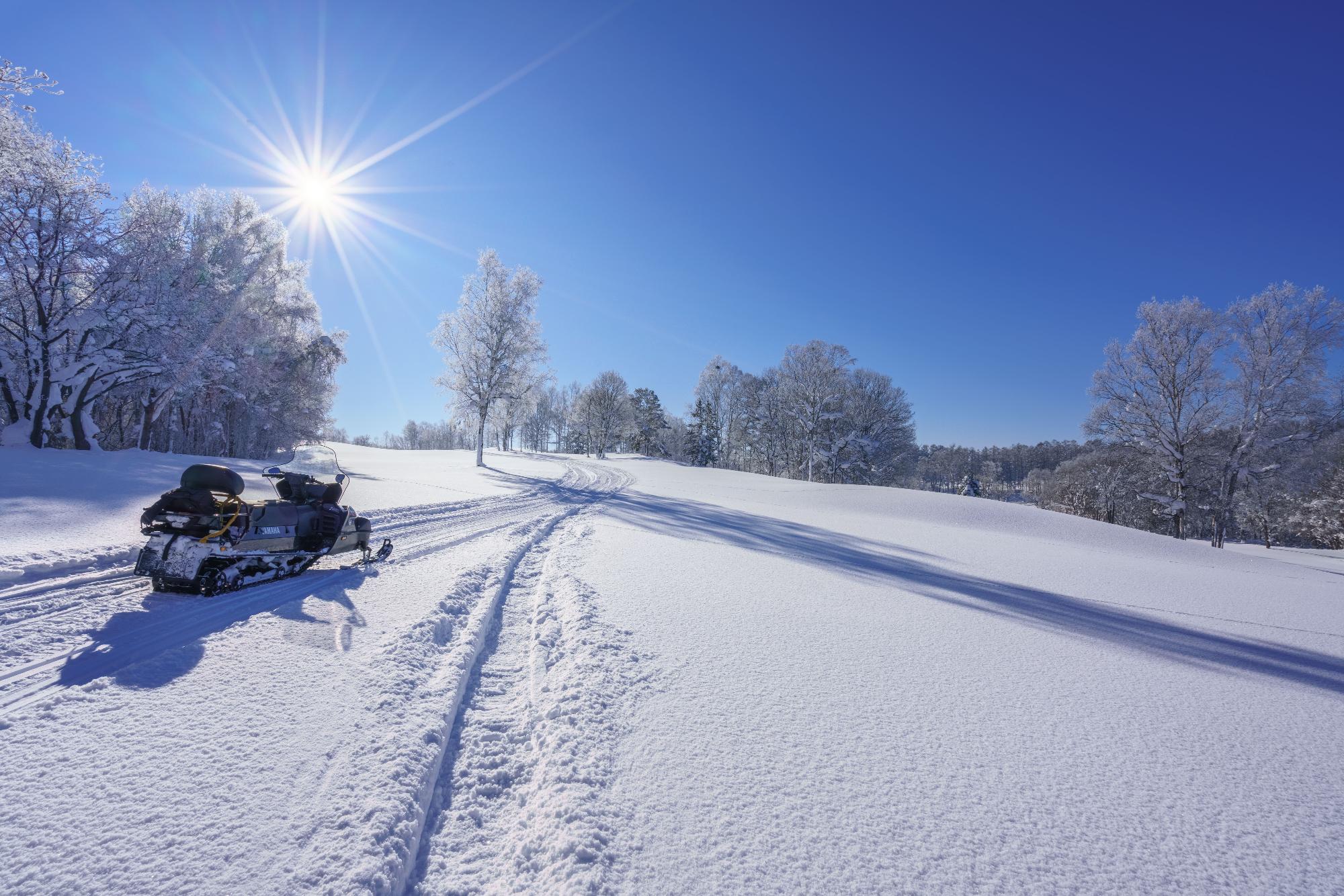 一面の雪景色とスノーモビル