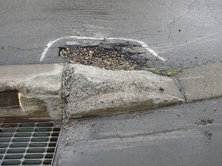 道路の側溝近くに穴が開いている写真