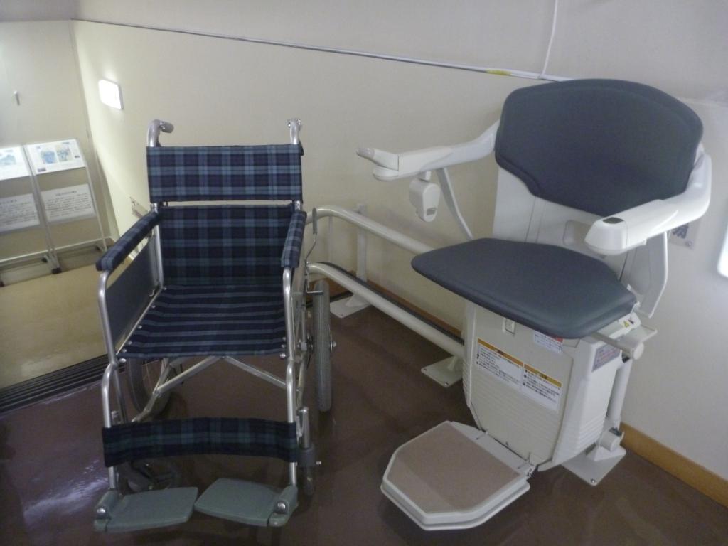 階段に設置された昇降機と車いすの写真