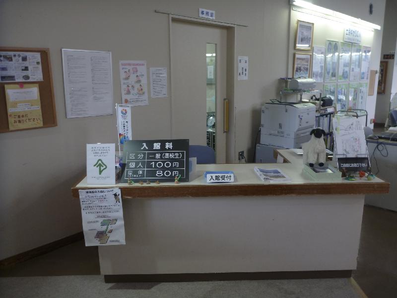 入館料の掲示やチラシなどが置かれている受付カウンターの机の写真