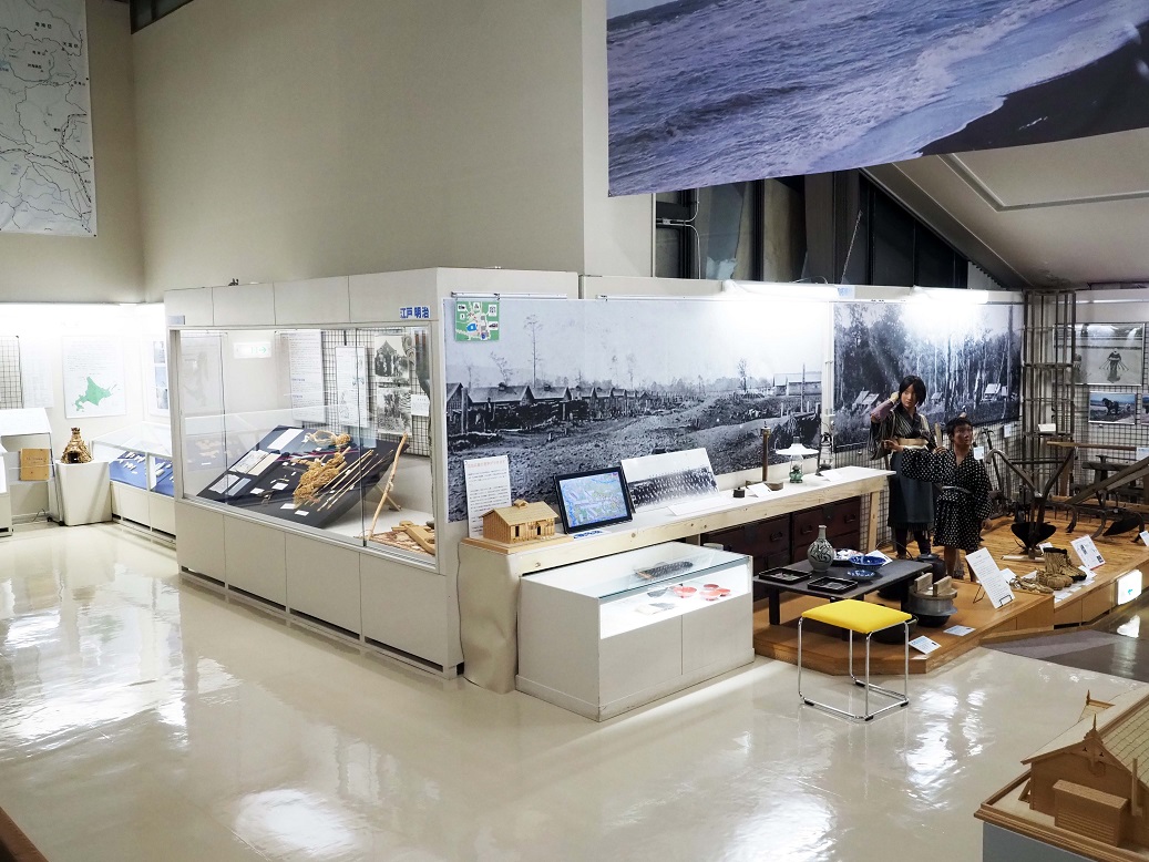 大きな写真やマネキン、ショーケースに入れられた資料などが展示されている士別市立博物館内の写真