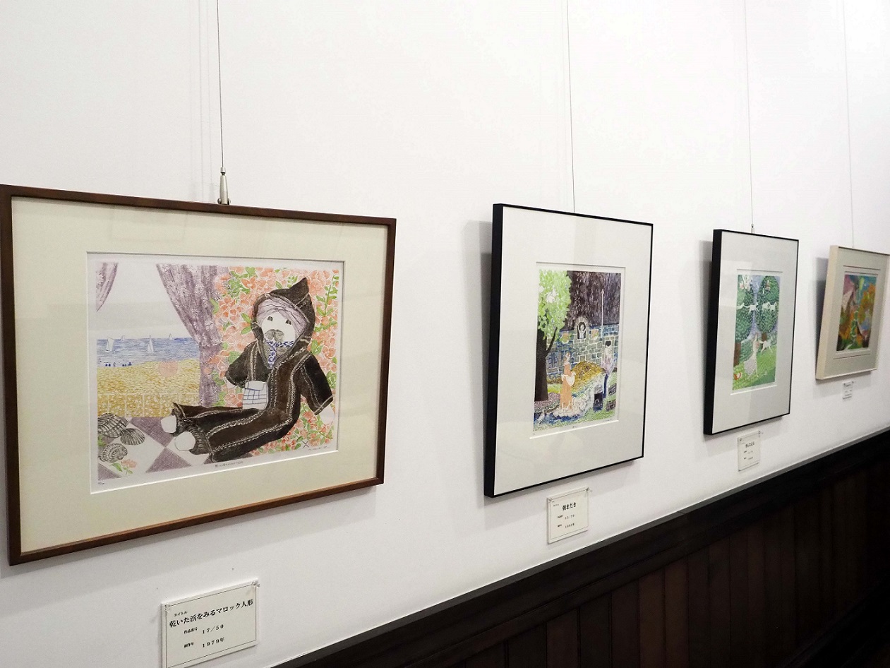 額に飾られた4枚の絵が上から吊り下げられて展示されている写真