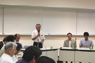 席を立ちマイクをもって発言している男性と席について話を聞いている参加者の写真
