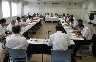 ロの字型に設置された席につき、手元の資料を見ながら話し合いをしている議会改革検討特別委員会の参加者の写真