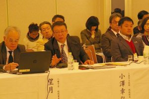 手ぶりを交えて話している男性の話を参加者達が聞いている様子の写真