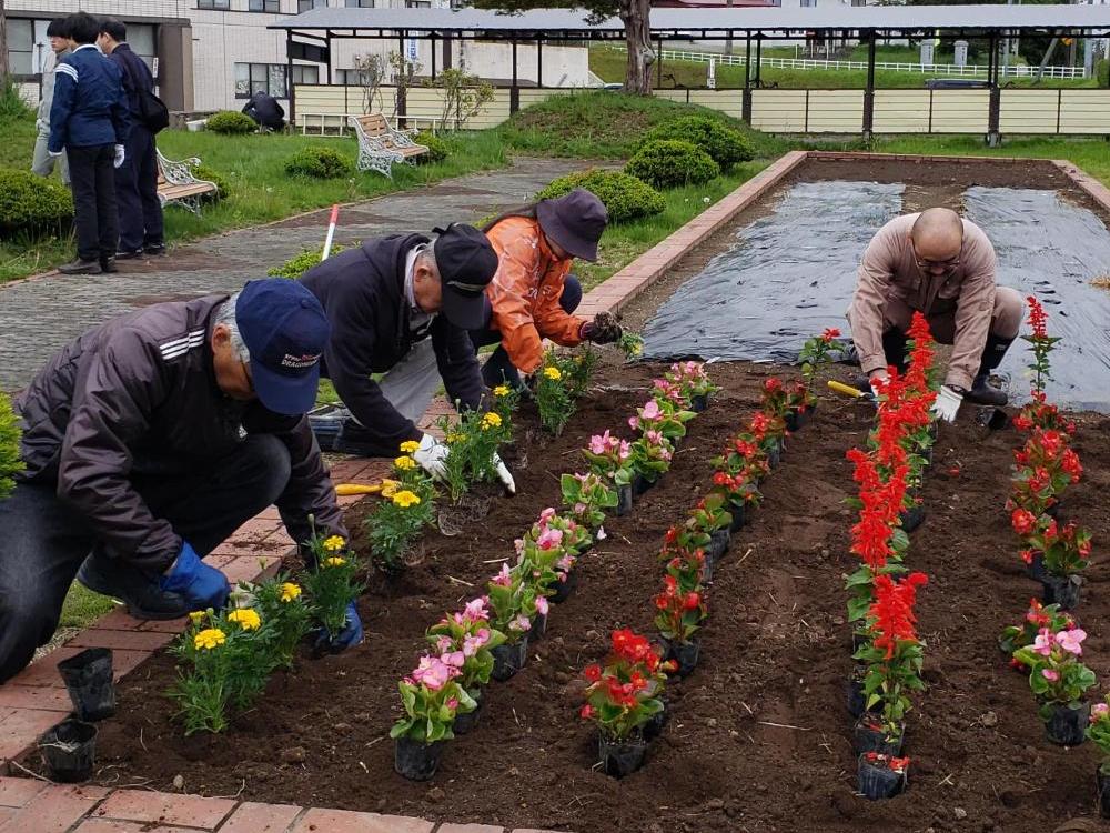 病院応援隊の皆さんが、花壇に花を植えている写真。