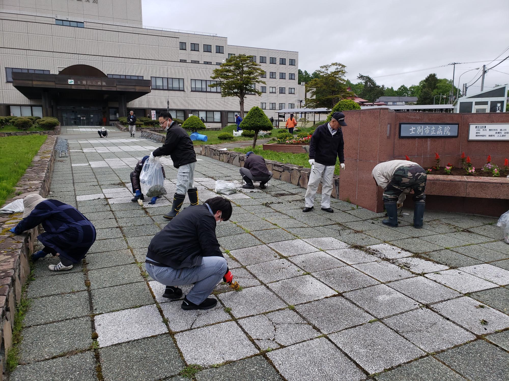 病院応援隊の皆さんが、病院敷地内の清掃や草とりをしている写真