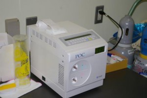 機械の上から検査結果の用紙が出力している尿素呼気試験の機器の写真