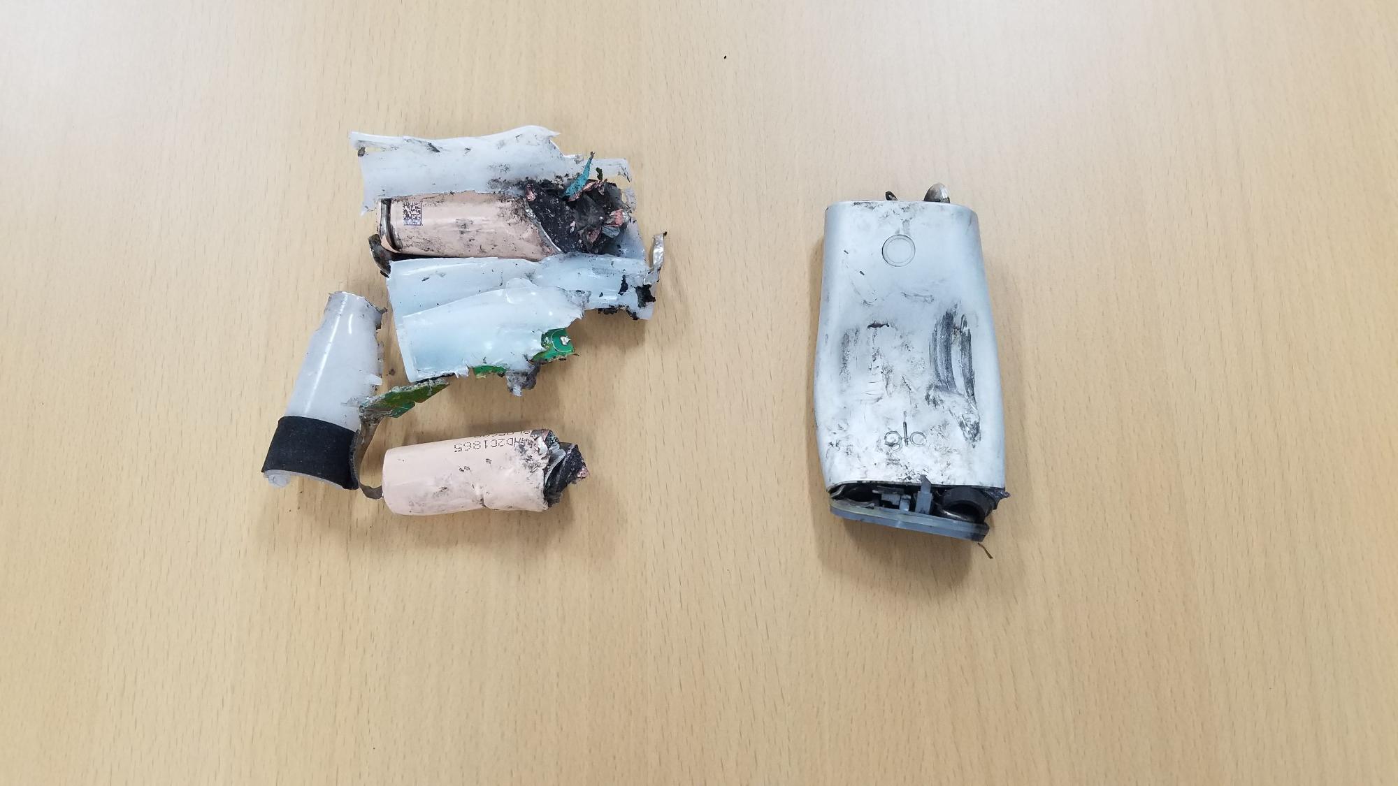 本体がへこんだ加熱式たばこの機械と破裂し粉々になった加熱式たばこの機械の写真