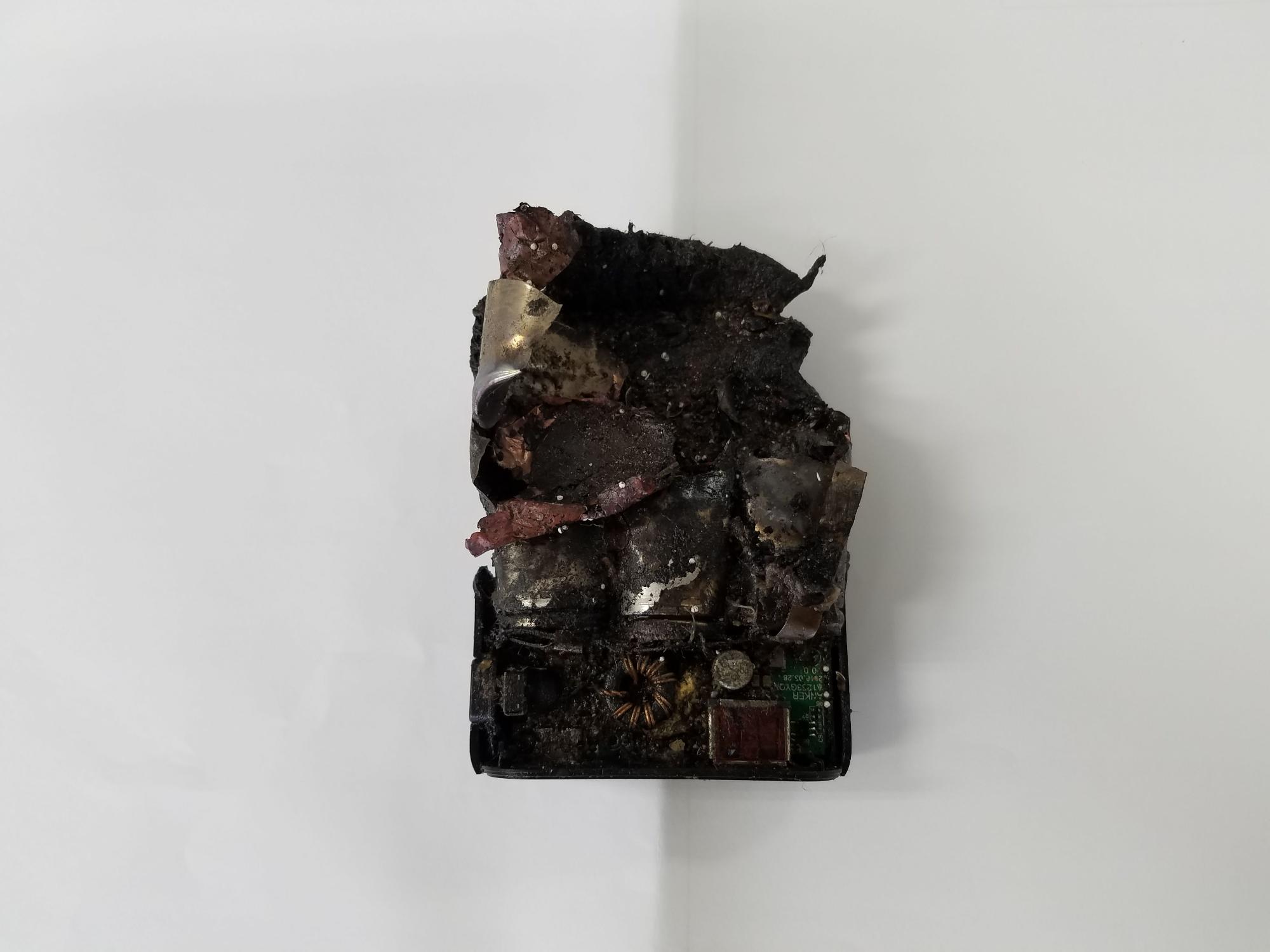 燃えて黒焦げになった充電式ラジオの写真