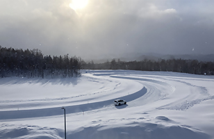 試験場の雪道で自動車走行試験を行っている写真