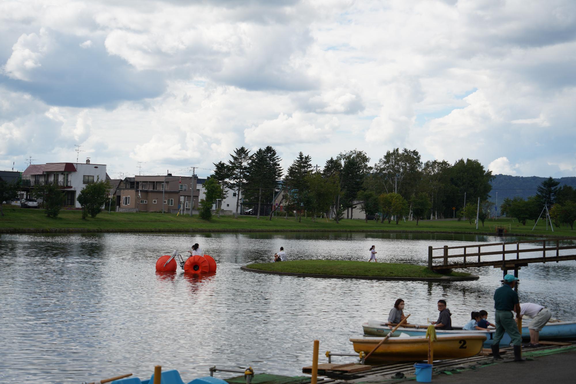 公園の湖でボートを楽しむ人の写真