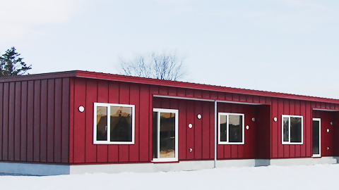 赤い外壁の平屋の市営住宅の画像