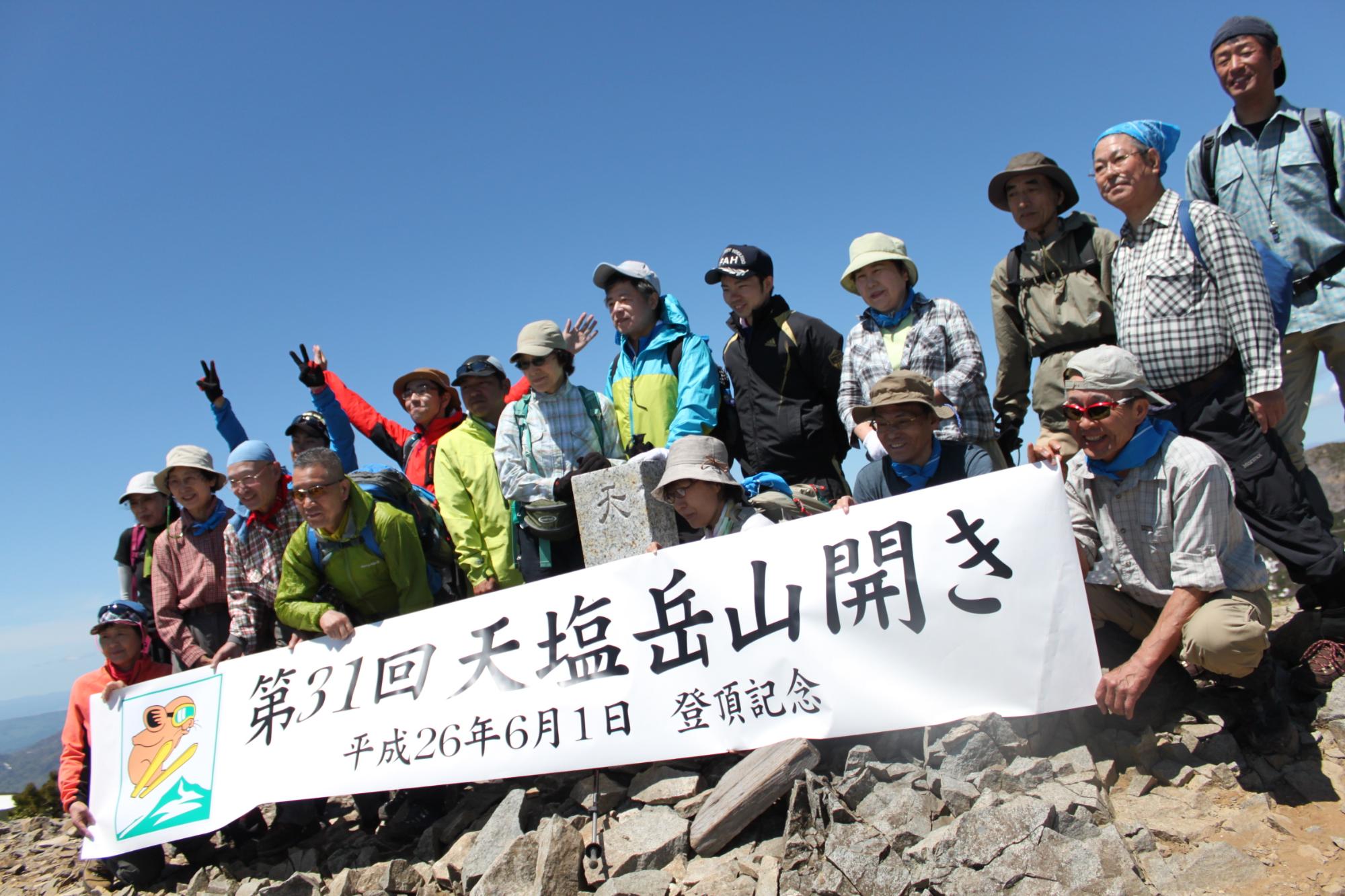 第31回天塩岳山開きと書かれた横断幕を持ち参加者の人達の記念写真