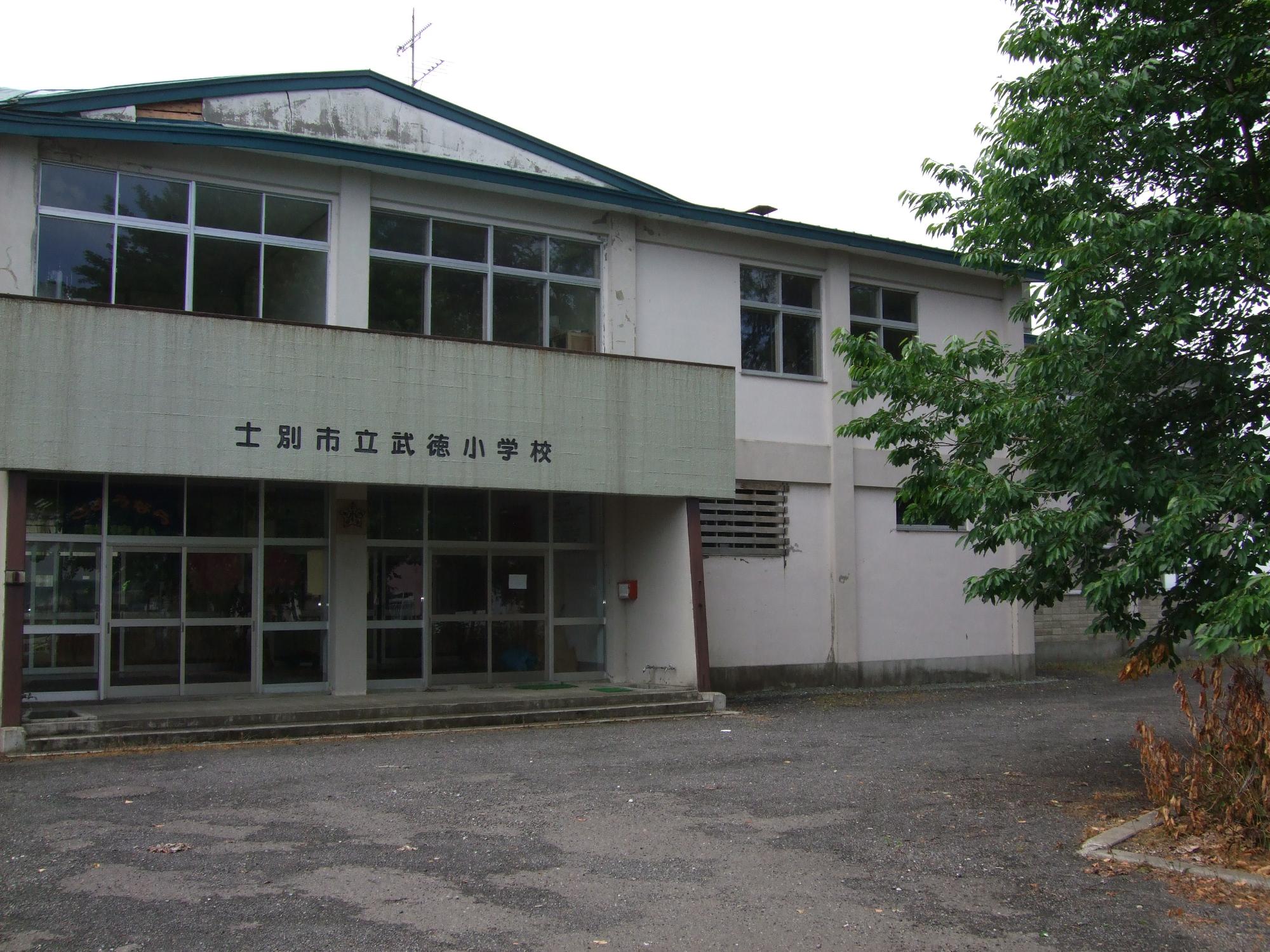 校舎の入り口上に「士別市武徳小学校」と書かれた2階建ての旧武徳小学校の校舎の写真
