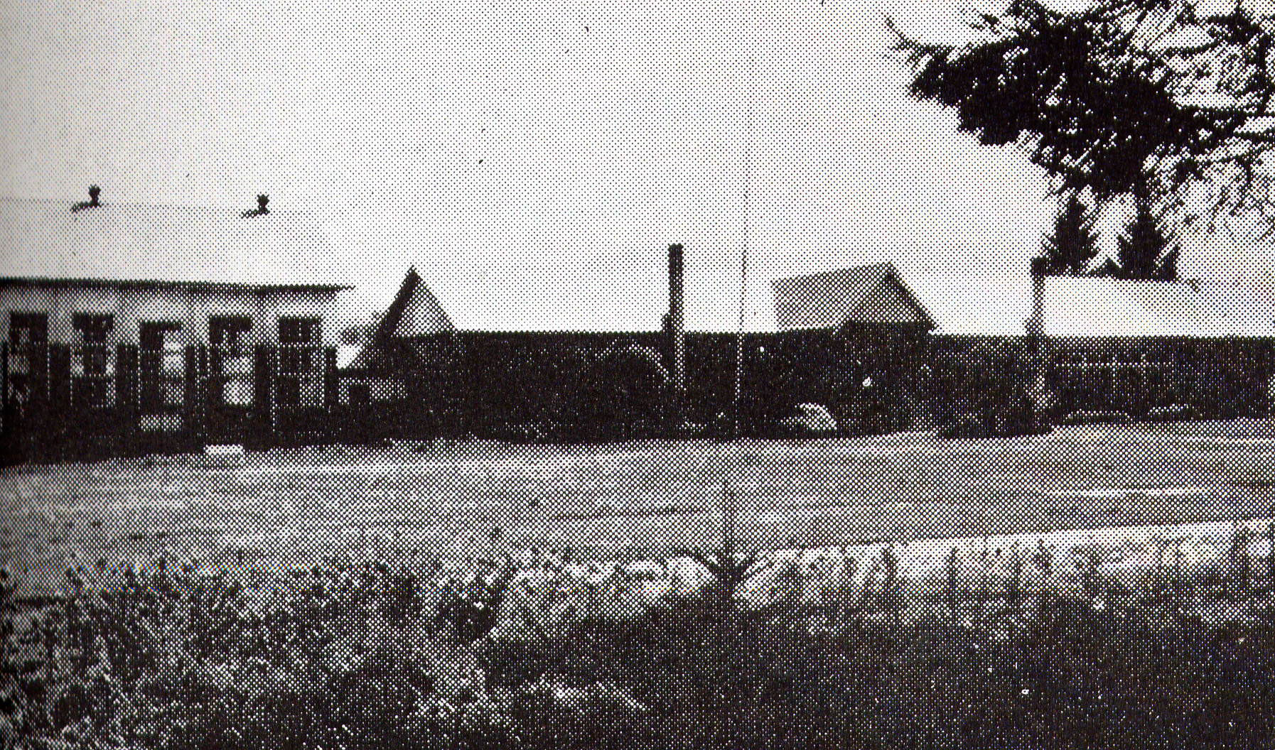 左右に煙突が設置された旧大和小学校校舎を校庭から撮影した白黒写真