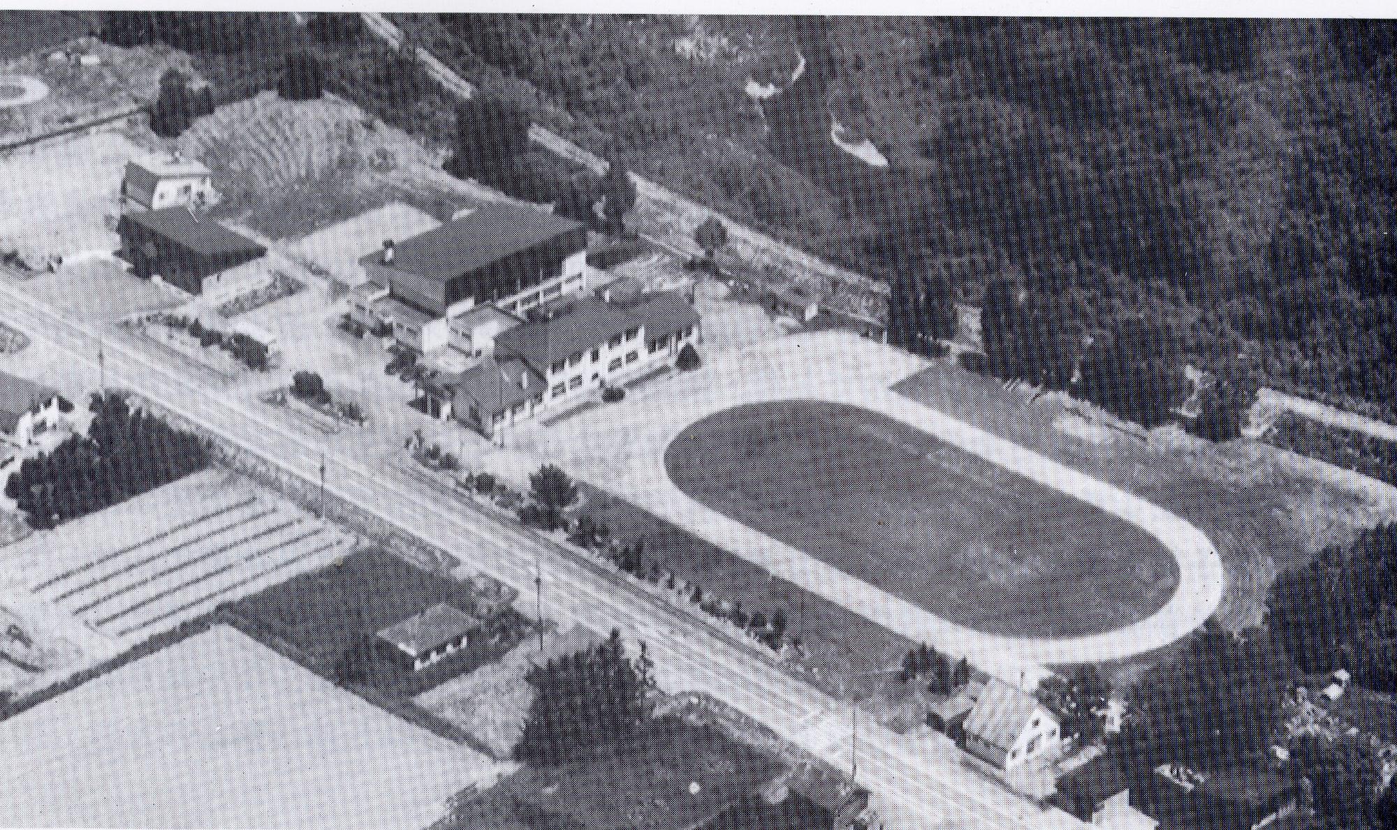 左側に校舎が建ち右側に校庭のある旧白山小学校校舎を上空から撮影した白黒写真