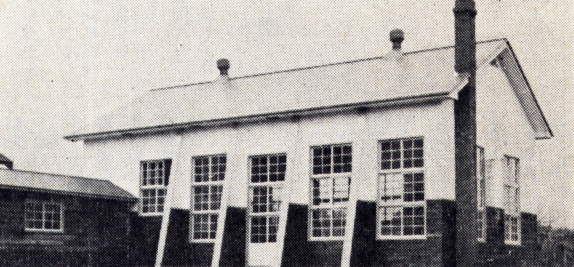 右外側に大きな煙突が設置された旧仲線小学校体育館の白黒写真