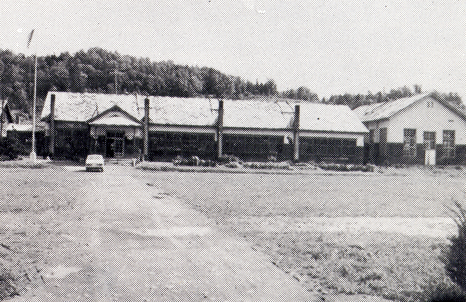 左側に入り口が設けられた旧伊文小学校校舎を校庭から撮影した白黒写真