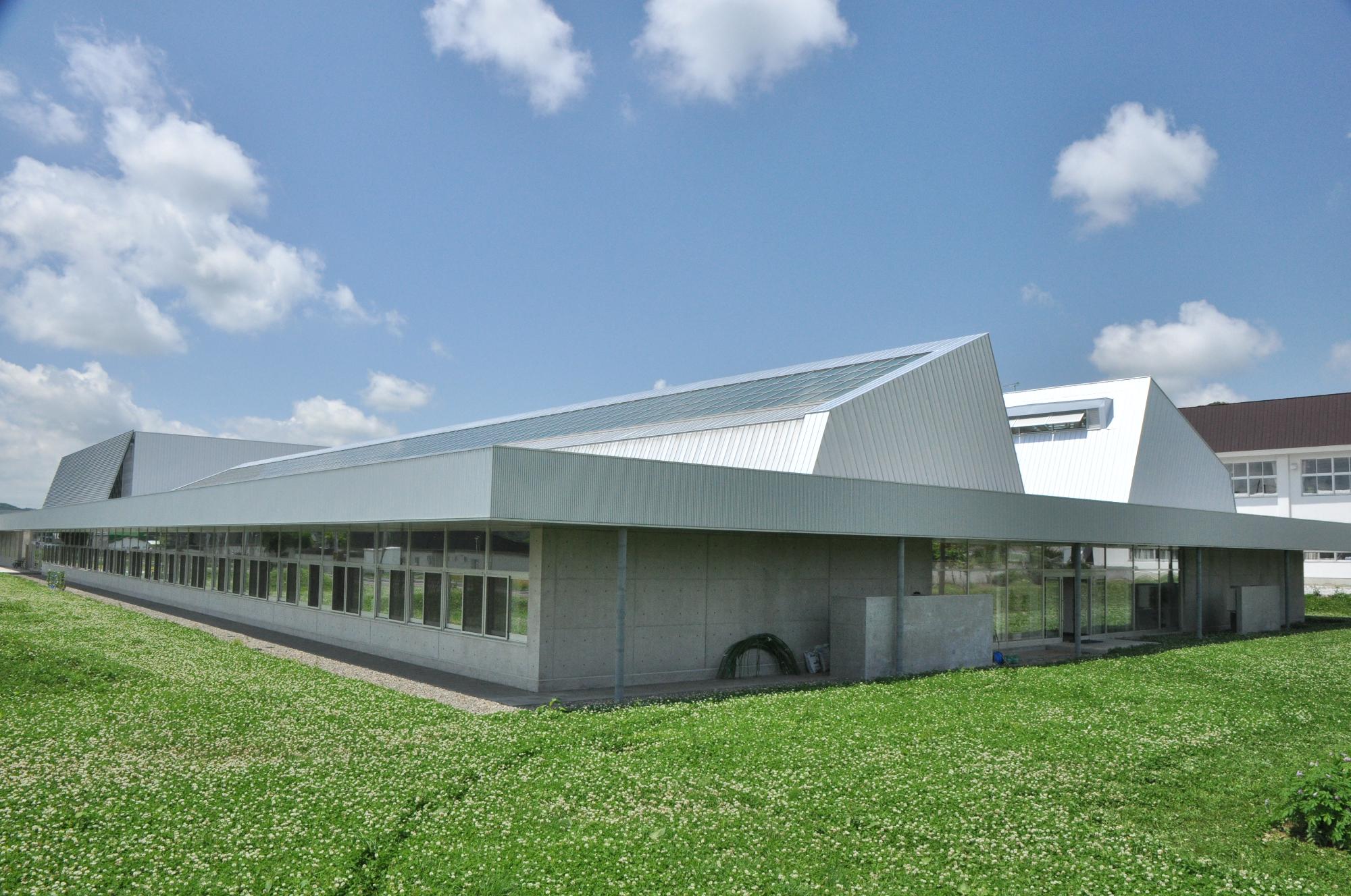 屋根に太陽光パネルが設置されコンクリート造りの糸魚小学校の校舎の写真
