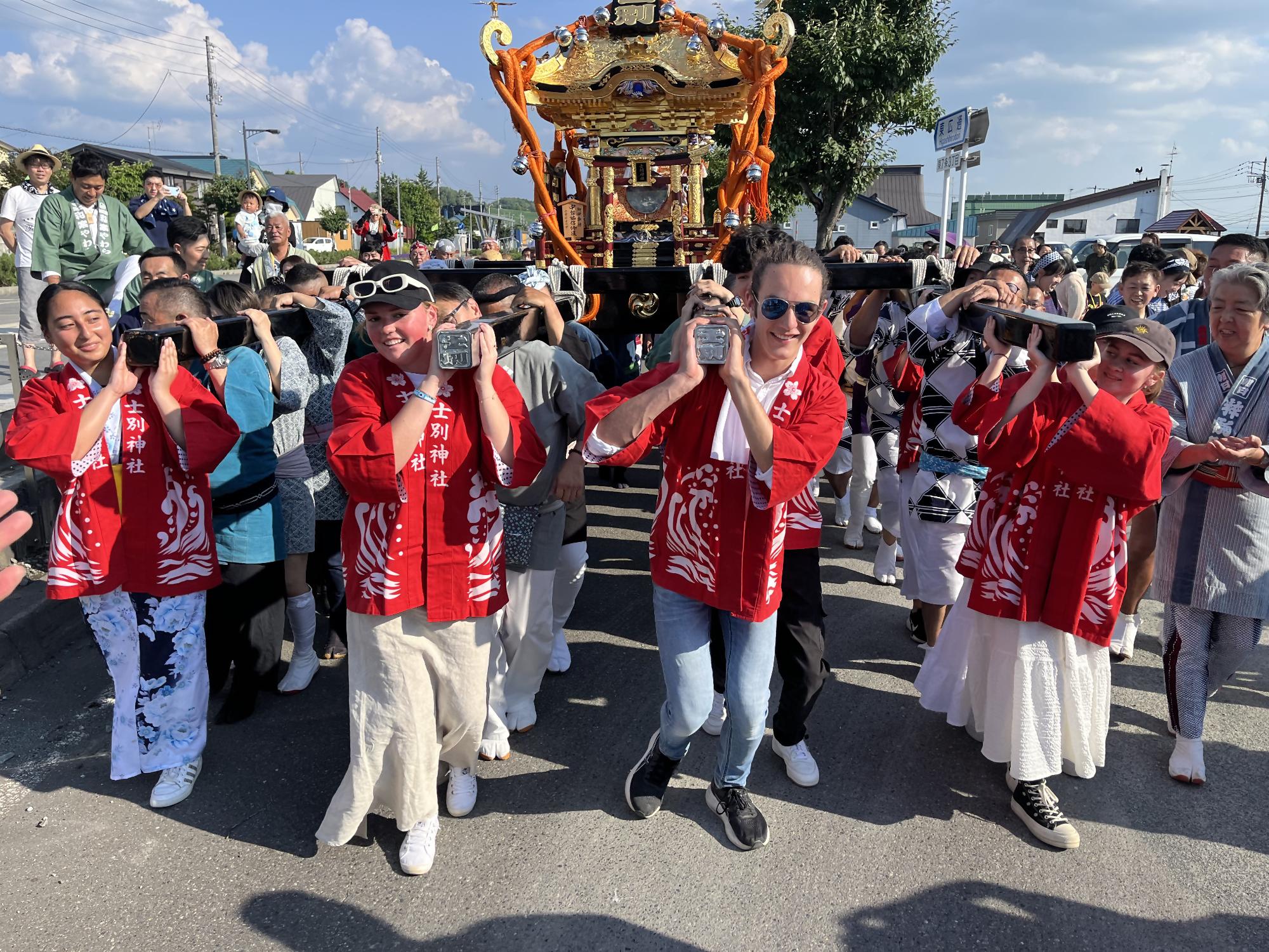 外国人留学生がみこしを担いでいる写真