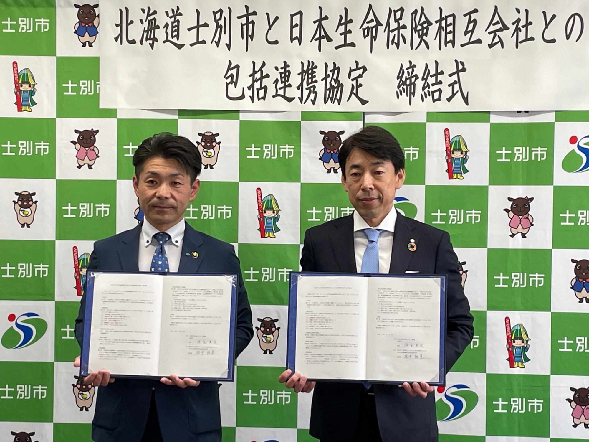 渡辺市長と根津支社長が協定書を掲げて並んでいる写真