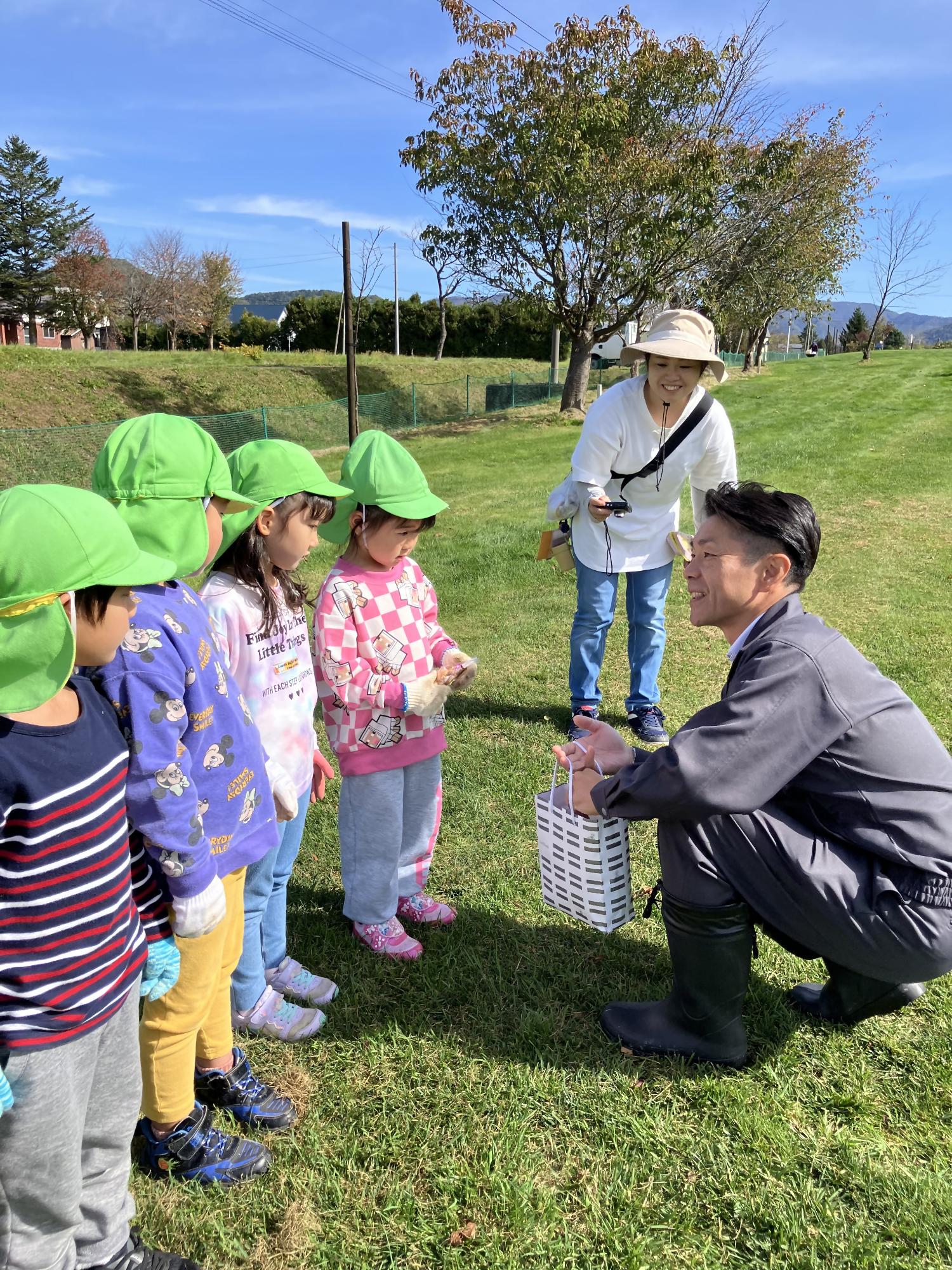 植樹を終え、市長から記念品をもらう園児たちの写真