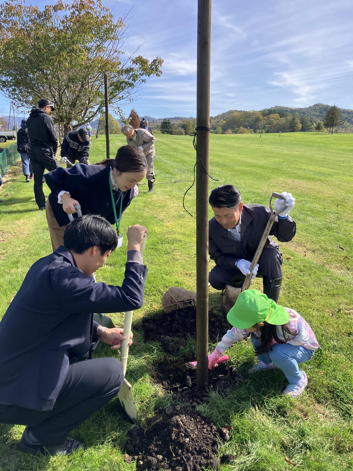 市長・園児・北海道銀行職員が一緒に植樹をする様子