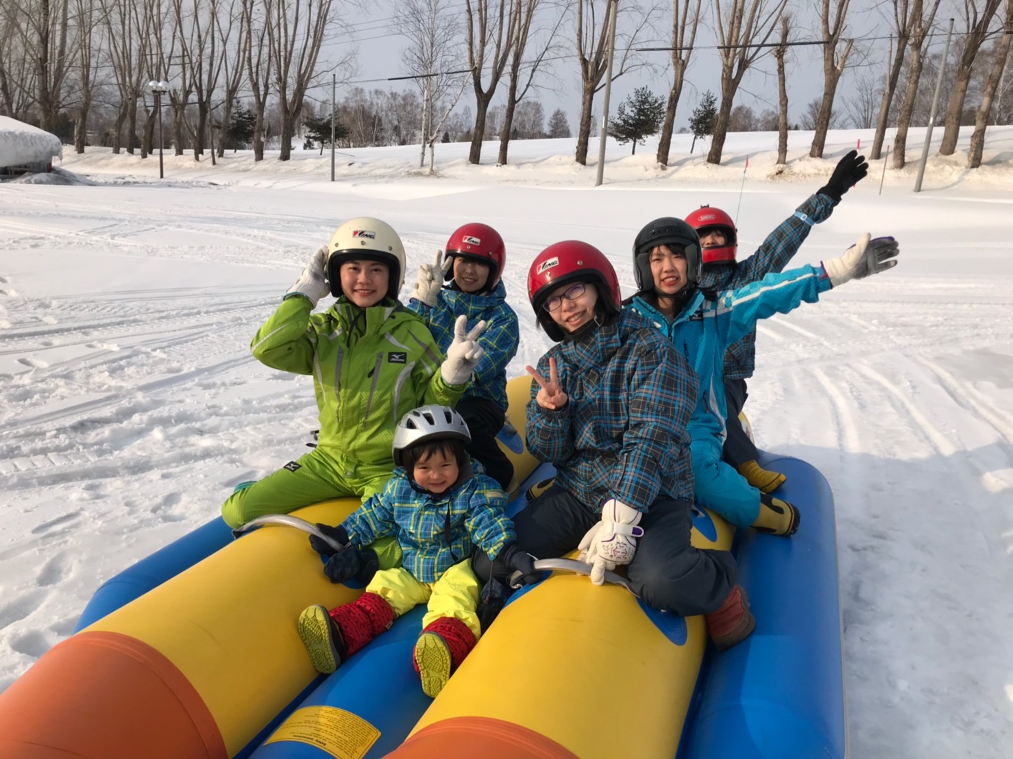 モニターツアー事業（辺り一面に積もった雪の上でバナナボートに乗っている子供たち）の写真
