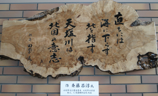木に書かれた銘板（斉藤昌淳氏の作品）の写真
