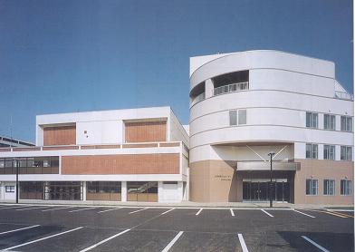 壁が白色とベージュ色で統一された左が3階建て、右が4階建ての士別市民文化センターの建物外観の写真