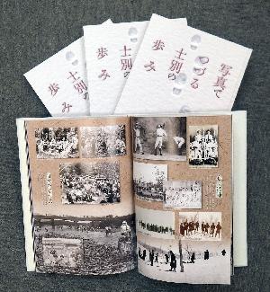 「写真でつづる士別の歩み」3冊の写真集とその上に1冊の写真集が開かれた状態で置かれている写真