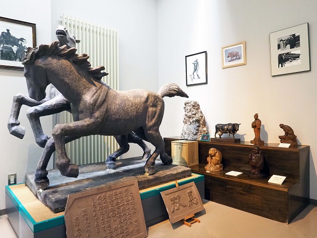 大きな馬の彫刻や、その他牛や七福神の彫刻や絵が飾られている区画の写真