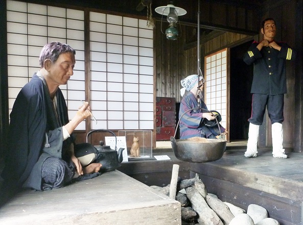 囲炉裏や人形など、当時の生活風景を再現した屯田兵屋の内部の写真