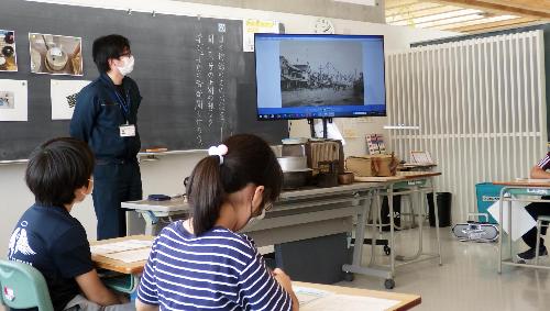 小学校に出向いて昔の人々の暮らしについて解説する学芸員