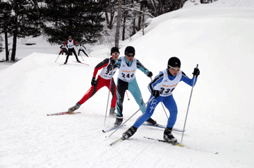 スキーウェアにゼッケンを付けた3名の選手が朝日クロスカントリースキーコースでトレーニングをしている写真