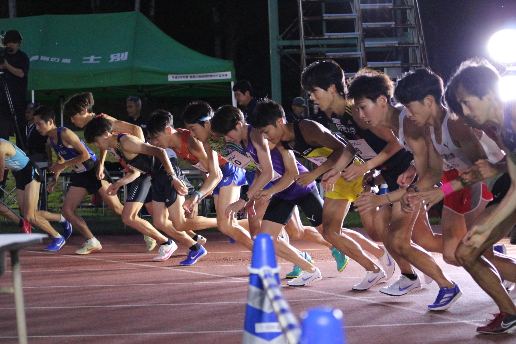 ペースメーカーの後ろを集団で走る男子選手の写真