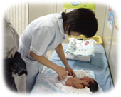 赤ちゃんのおむつを替えている看護師の写真