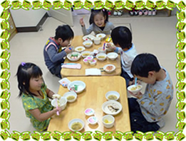 5名の園児が楽しそうに、話をしながら給食を食べている様子の写真