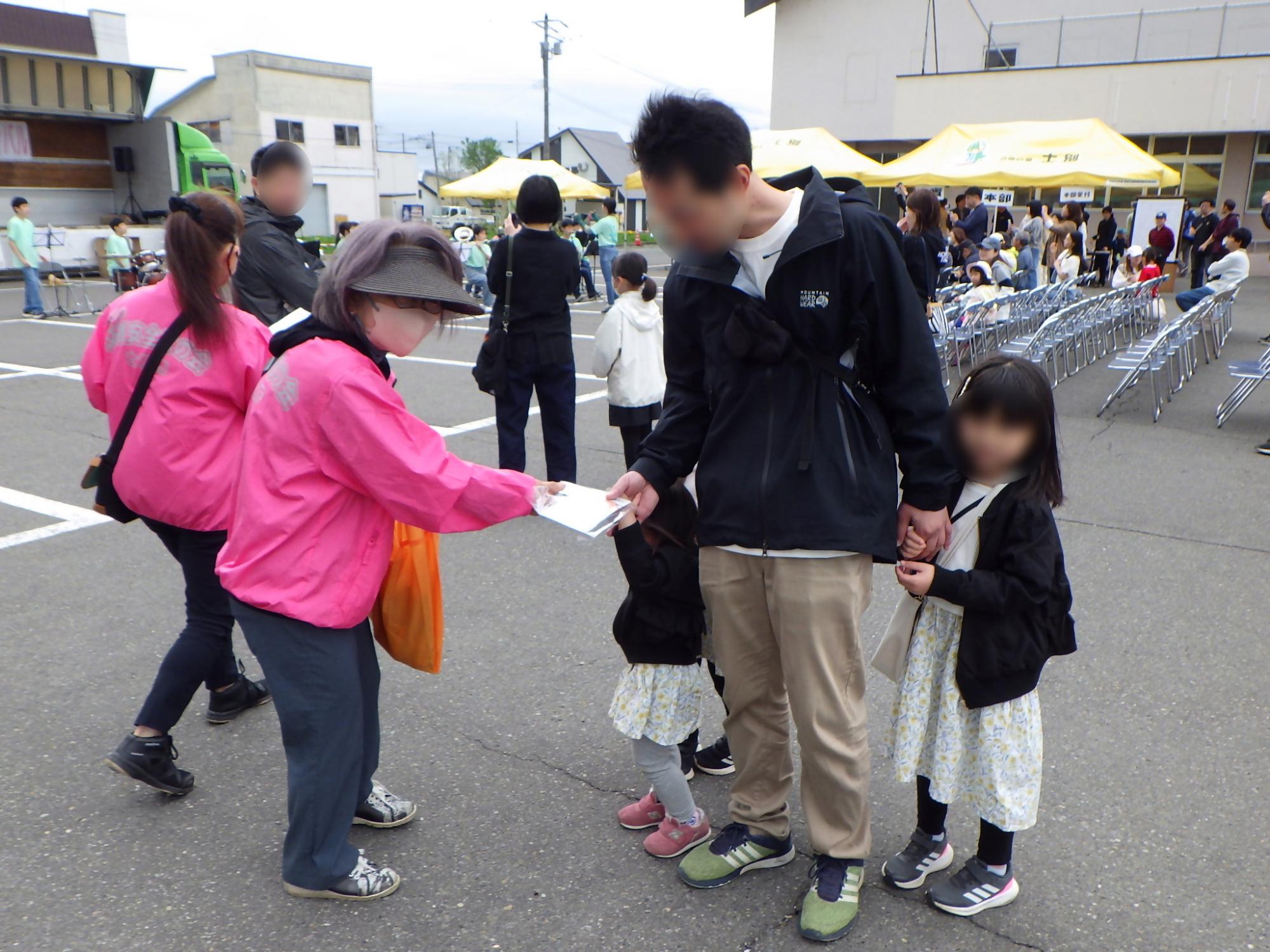 交通安全母の会役員がイベント来客者に交通安全を呼びかけているところ