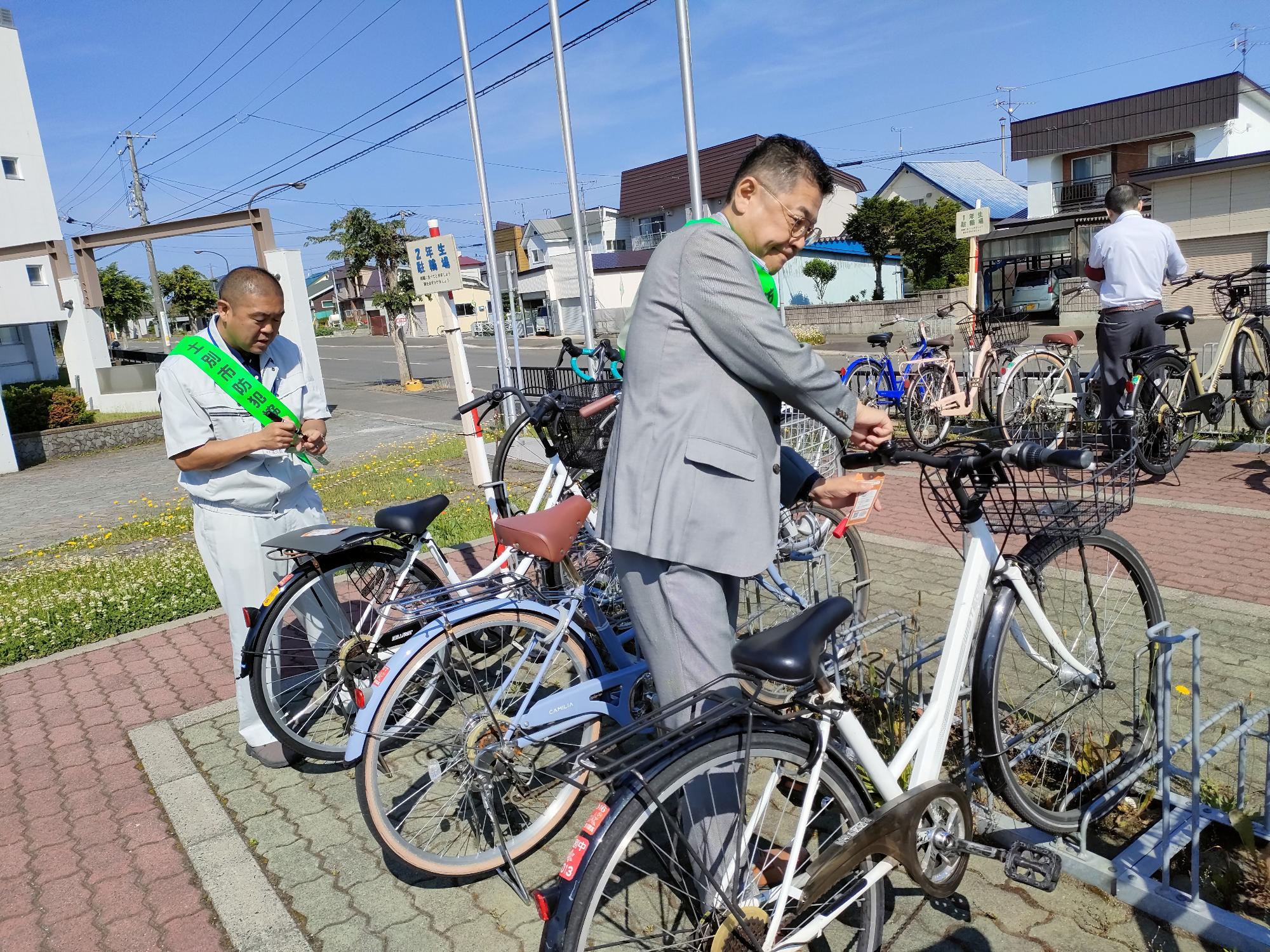 生徒の自転車の防犯登録やツーロックの確認をしているところ