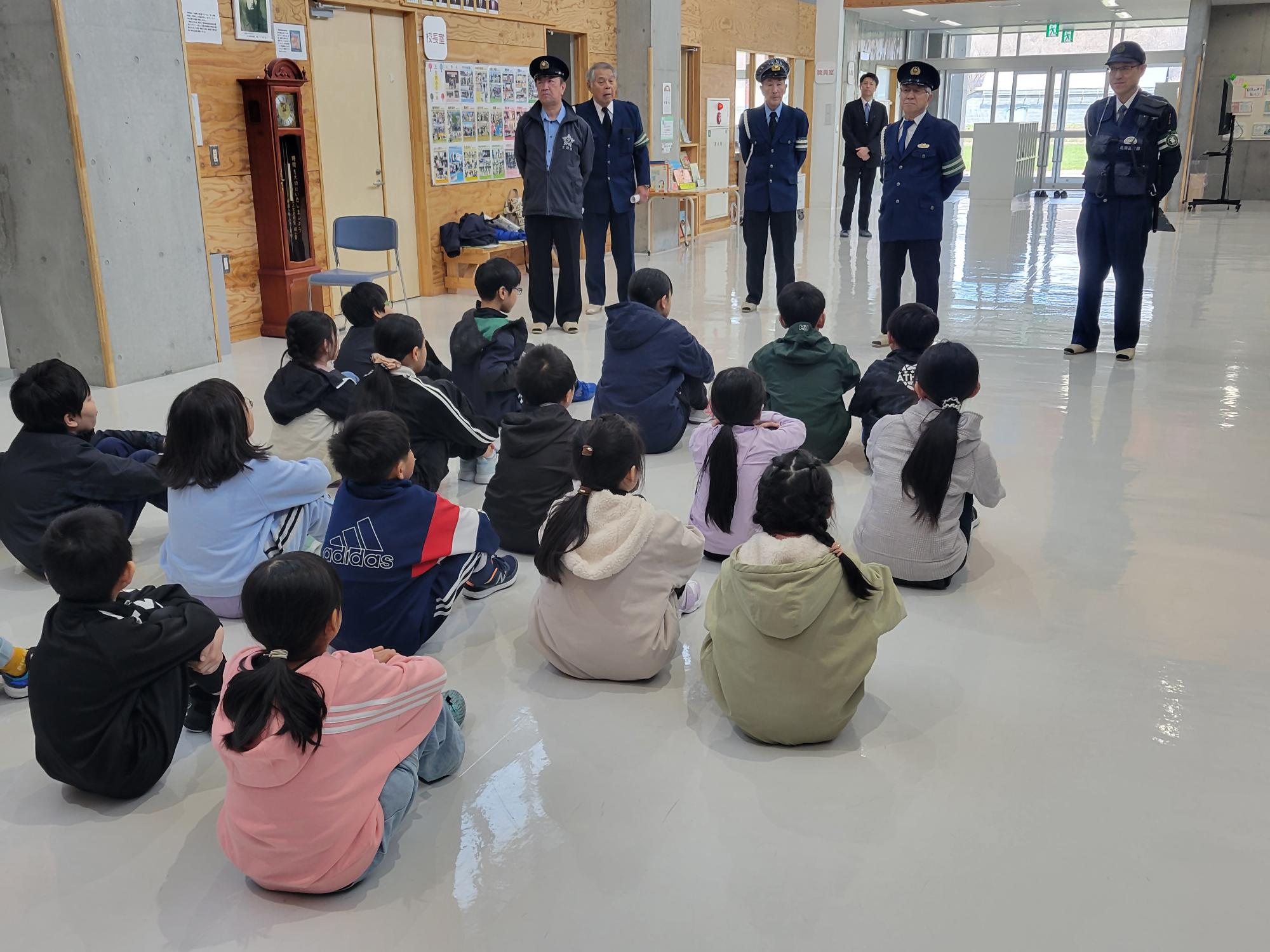 交通安全指導員が小学校の交通安全教室でルールのお話しているところ