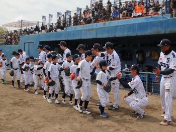 選手が少年野球チームの子供たちとハイタッチしている写真