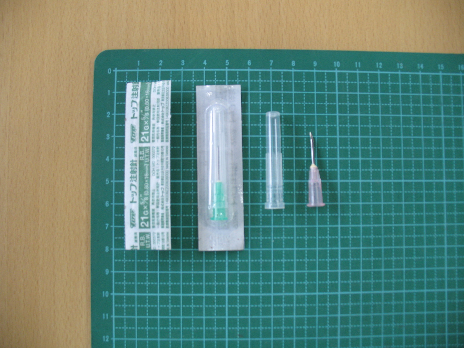 袋に入っている未使用な針や使用済みの注射針を並べた写真